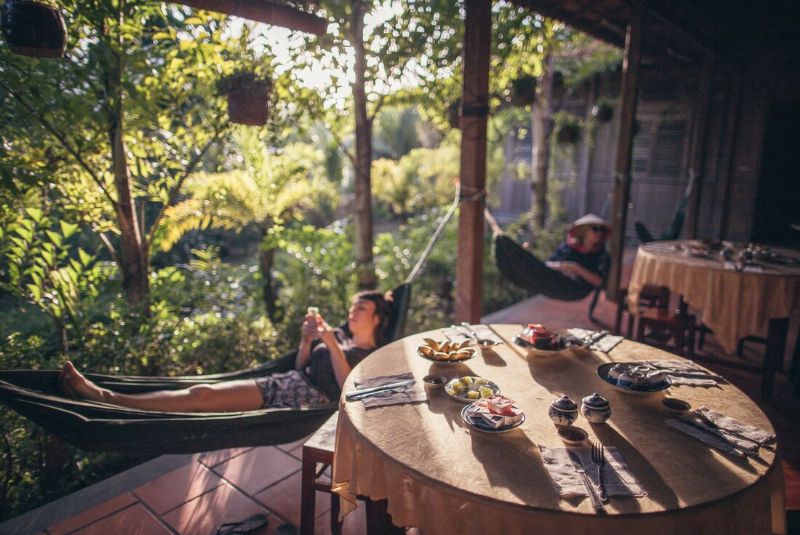 intrepid travel-vietnam mekong-delta homestay tables-traveller-hammocks